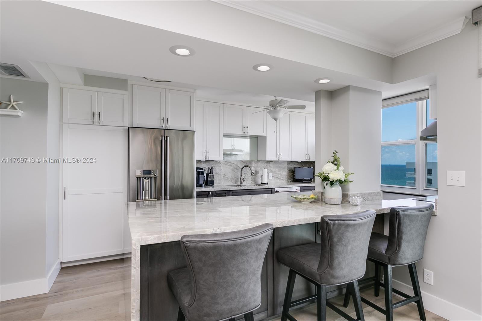 1200 South Ocean Boulevard, Unit PHF Boca Raton, FL 33432 - Photo 8 of 65 a kitchen with stainless steel appliances granite countertop a dining table chairs refrigerator and sink