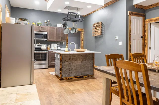 a kitchen with stainless steel appliances granite countertop a sink dishwasher a refrigerator and cabinets with wooden floor