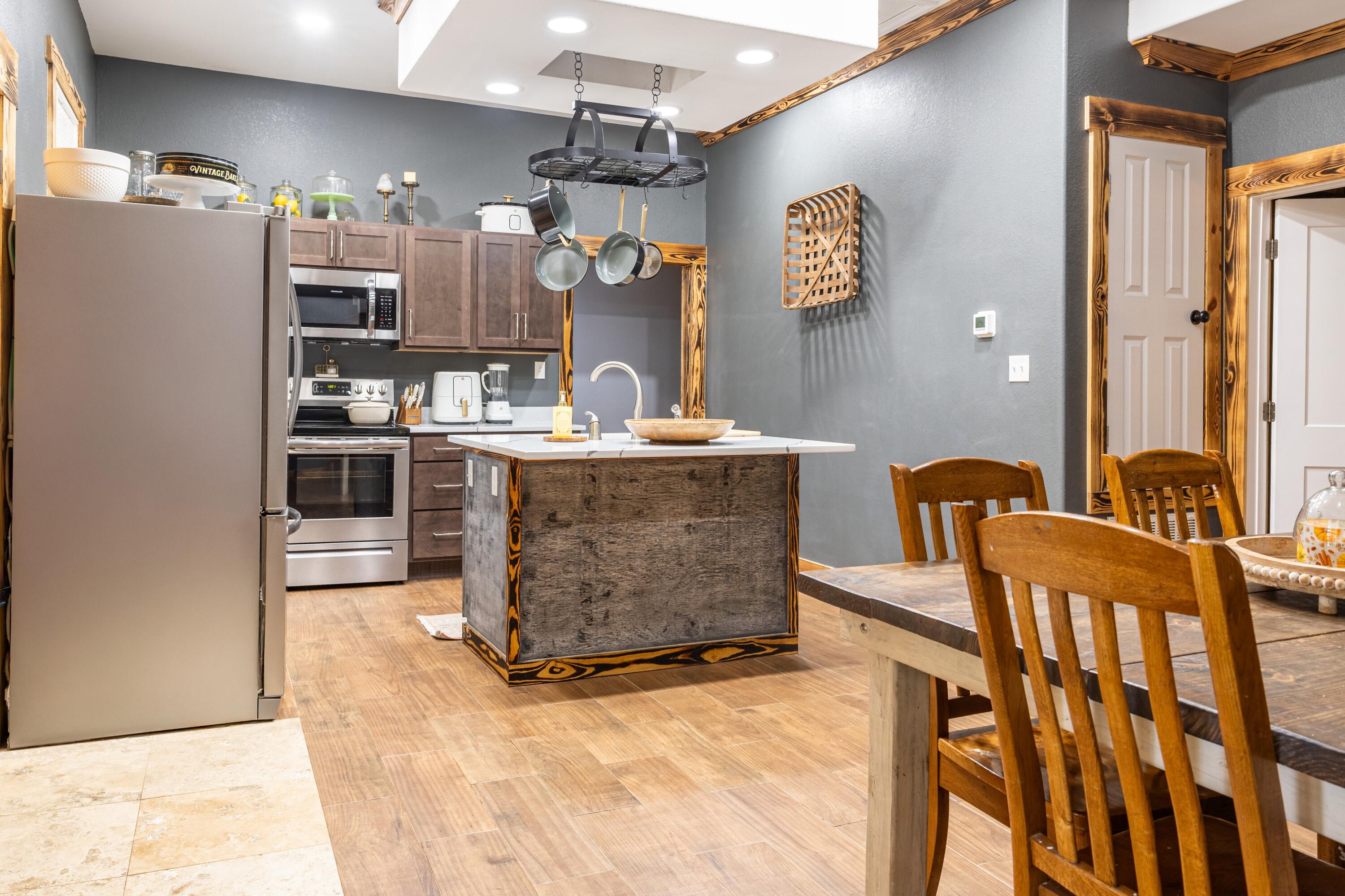 981 East Chestnut Avenue Crestview, FL 32539 - Photo 11 of 64 a room with stainless steel appliances kitchen island granite countertop a refrigerator a stove and a sink with living room view