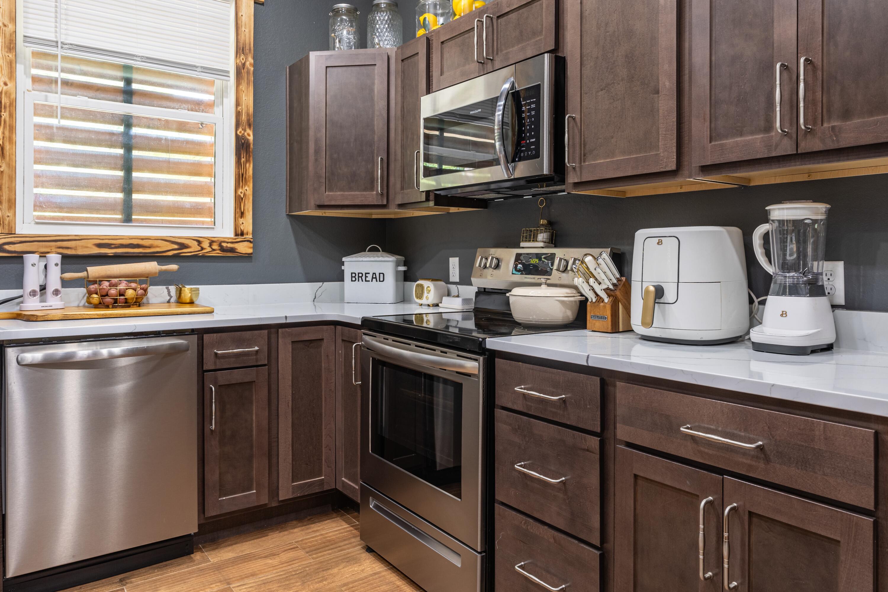 981 East Chestnut Avenue Crestview, FL 32539 - Photo 13 of 64 a kitchen with stainless steel appliances granite countertop a sink dishwasher a refrigerator and cabinets with wooden floor