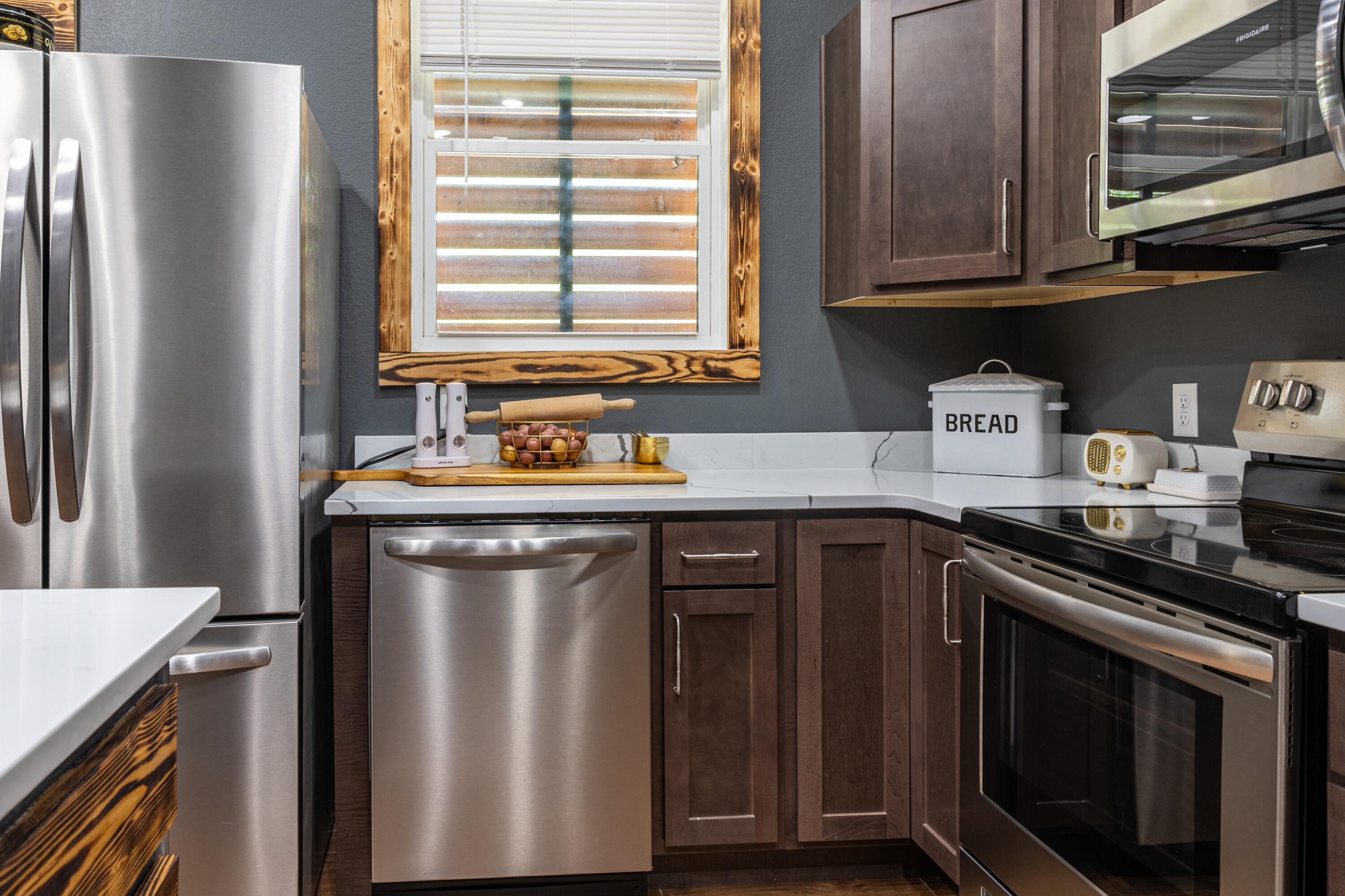 981 East Chestnut Avenue Crestview, FL 32539 - Photo 14 of 64 a kitchen with stainless steel appliances granite countertop a refrigerator sink and stove