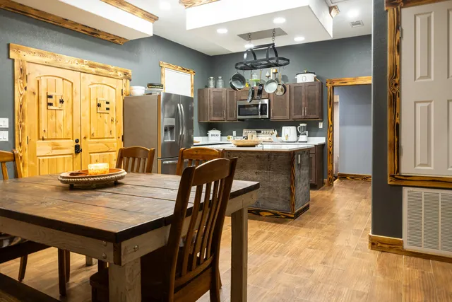a kitchen with stainless steel appliances a stove a refrigerator and a dining table