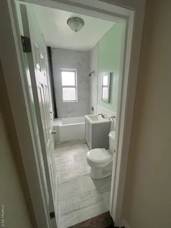 a white toilet sitting next to a bathroom sink