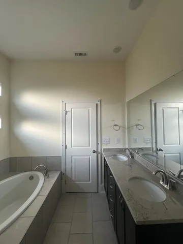 a bathroom with a granite countertop bathtub sink and mirror
