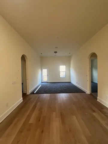 a view of empty room with window and wooden floor