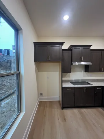 a view of kitchen with stainless steel appliances granite countertop wooden cabinets and a sink