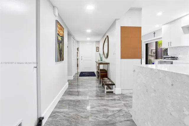a view of a hallway with wooden floor and a living room