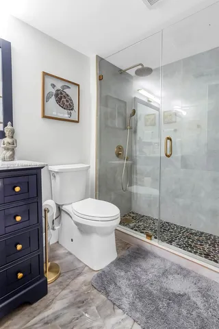 a bathroom with a toilet a sink and shower