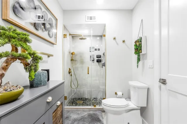 a bathroom with a granite countertop sink a toilet and shower