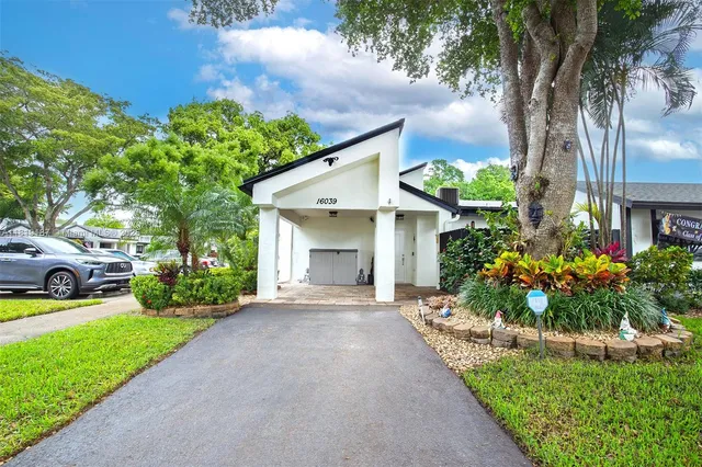 a front view of a house with a yard and a garden