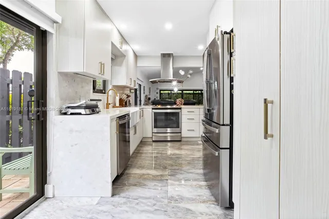 a kitchen with stainless steel appliances granite countertop a stove a refrigerator and a sink