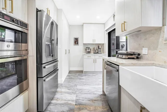 a kitchen with stainless steel appliances a refrigerator sink and stove