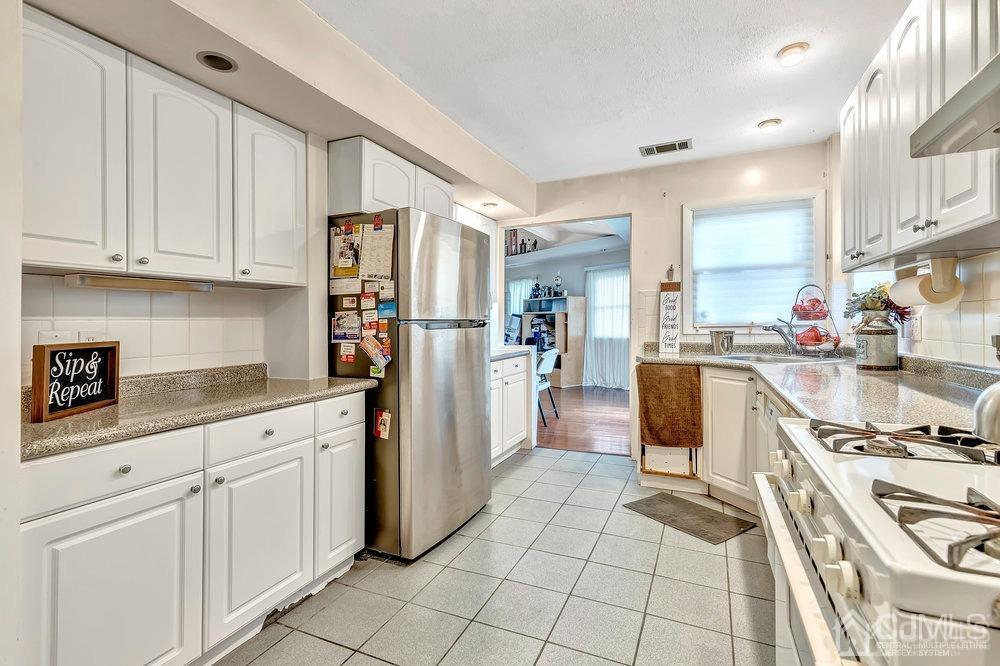 122 Vineyard Road Edison, NJ 08817 - Photo 11 of 24 a kitchen with white cabinets and appliances