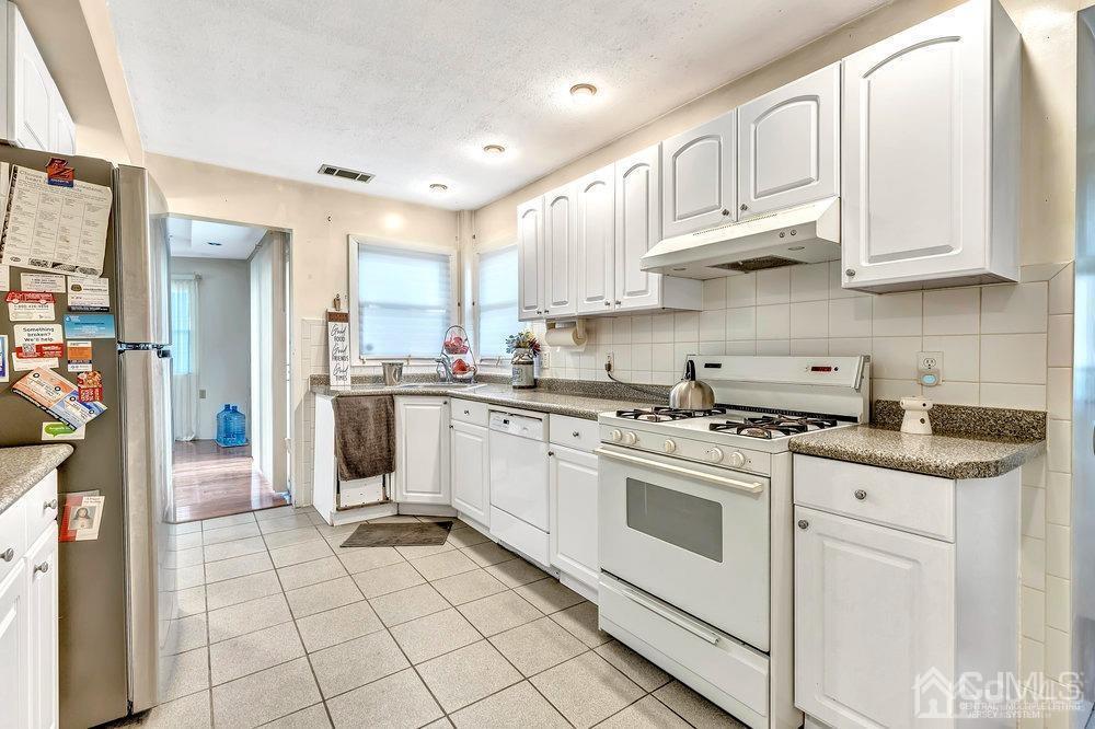 122 Vineyard Road Edison, NJ 08817 - Photo 9 of 24 a kitchen with white cabinets and appliances