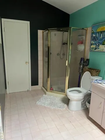 a white toilet sitting next to a bathroom sink and a shower