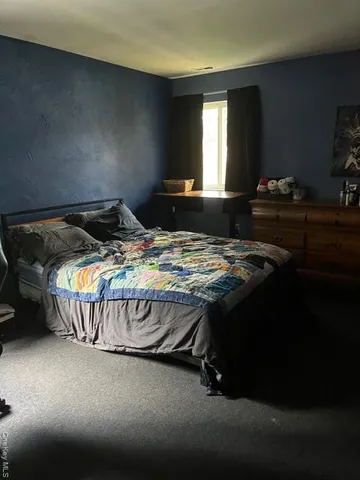 a bed sitting in a bedroom next to a window