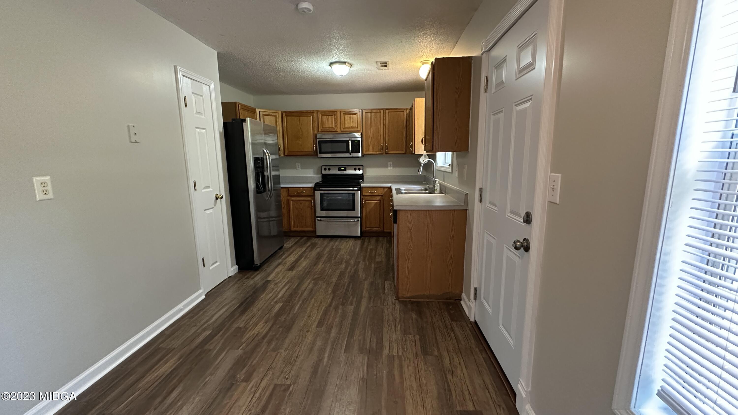 134 Haley Road Jackson, GA 30233 - Photo 3 of 11 a kitchen with a refrigerator and wooden floor