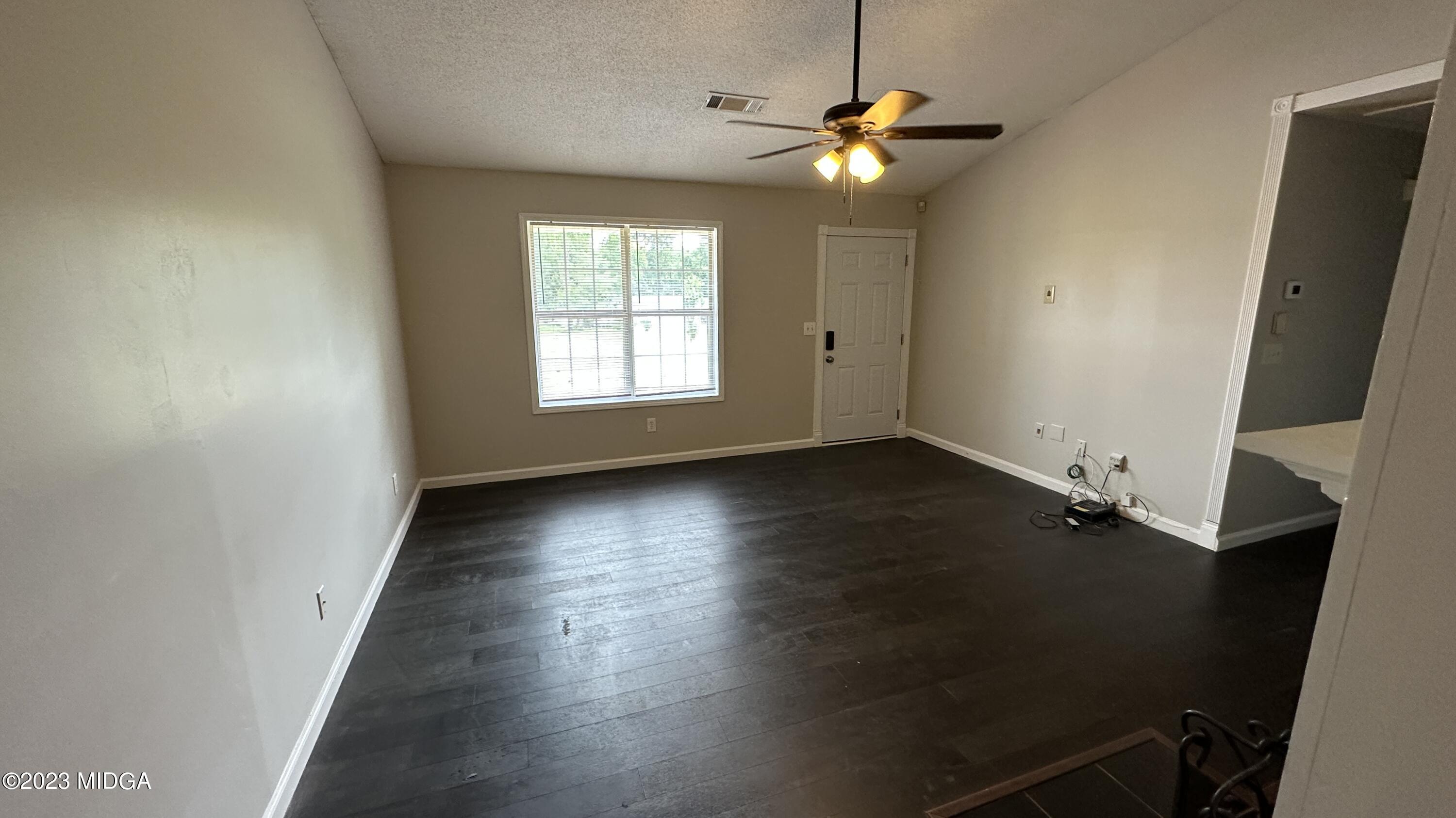 134 Haley Road Jackson, GA 30233 - Photo 10 of 11 an empty room with wooden floor fan and windows