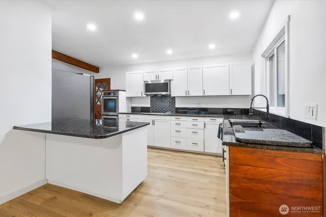a kitchen with stainless steel appliances granite countertop a sink stove and refrigerator