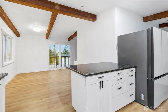a kitchen with granite countertop a refrigerator and a stove