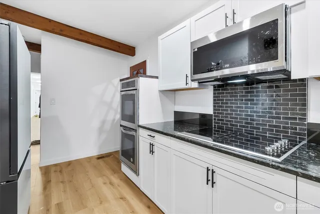 a kitchen with a sink and steel appliances