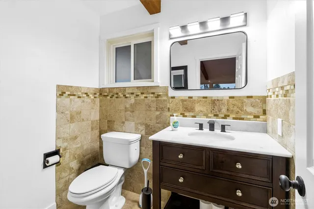 a bathroom with a sink vanity mirror and toilet