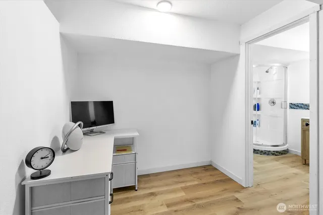 a view of workspace with wooden floor and bathroom
