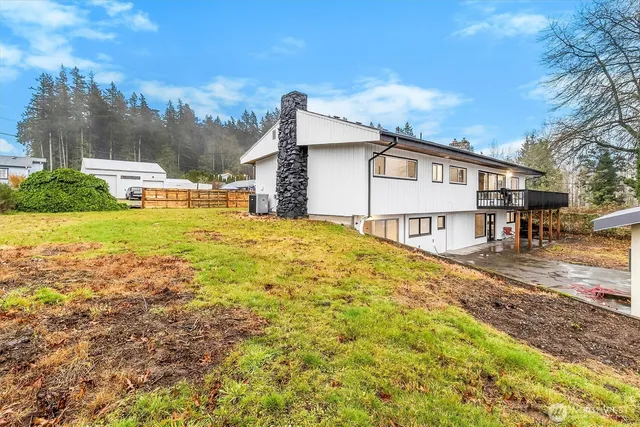 a view of a house with a yard covered with snow and trees