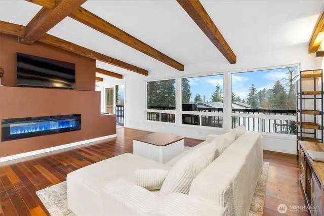 a large white bed sitting in front of a fireplace