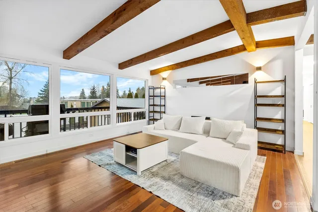 a living room with couches and a dining table with wooden floor