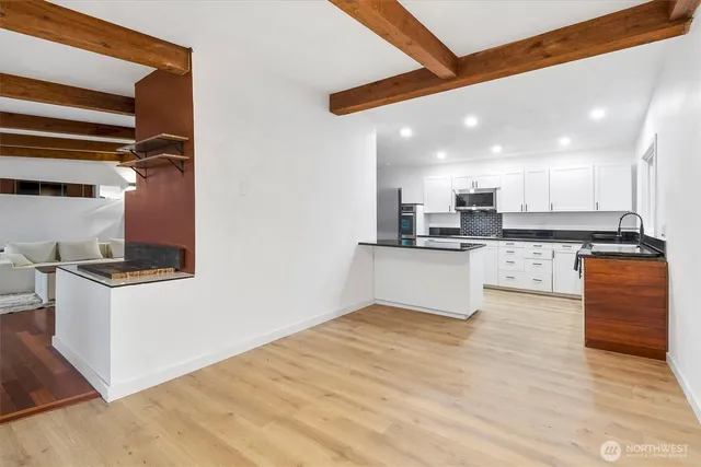 a kitchen with stainless steel appliances granite countertop a stove top oven a sink and a refrigerator