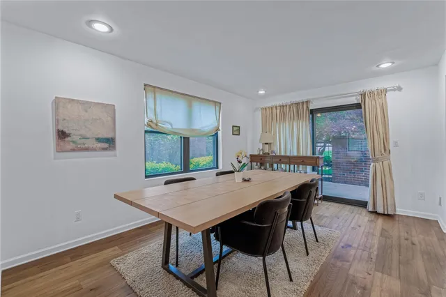 a living room with stainless steel appliances furniture a dining table and kitchen view