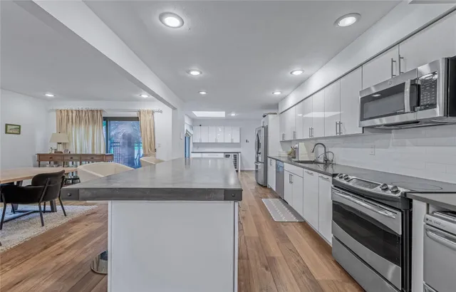 a kitchen with kitchen island a stove and a sink with wooden cabinets