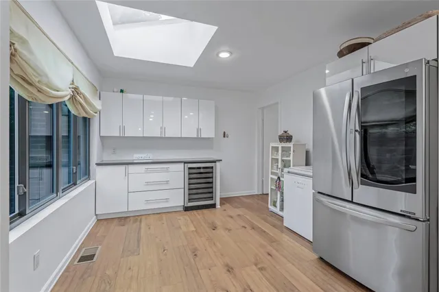 a kitchen with a refrigerator and white cabinets