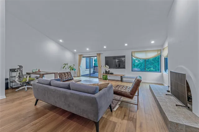 a living room with furniture flat screen tv and a large window