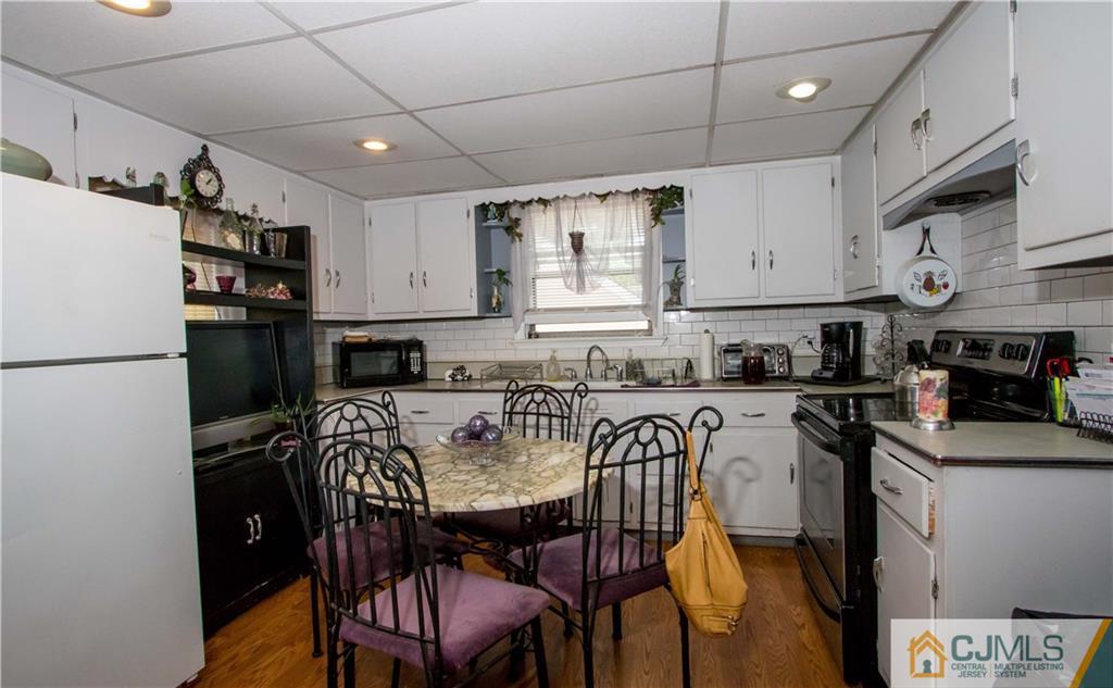 638 Florida Grove Road Perth Amboy, NJ 08861 - Photo 3 of 24 a kitchen with stainless steel appliances granite countertop a dining table chairs refrigerator and sink