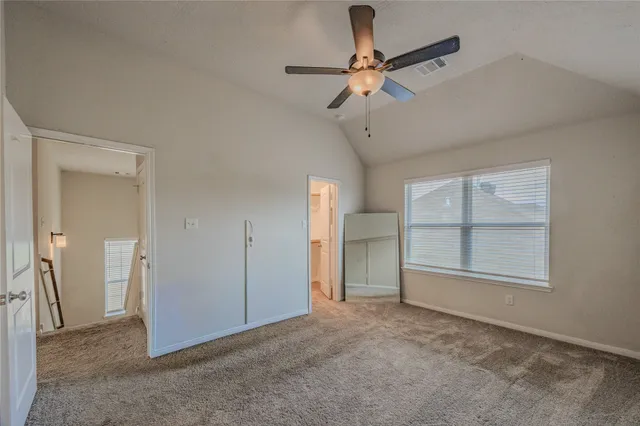 an empty room with a ceiling fan and a window