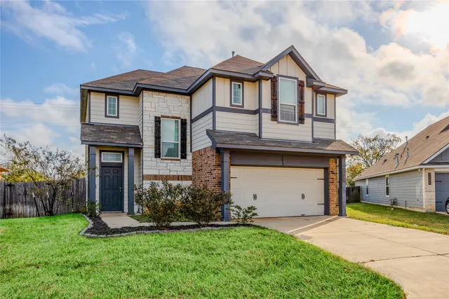 a front view of a house with a garden and garage