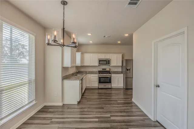a kitchen with stainless steel appliances a refrigerator and a stove top oven