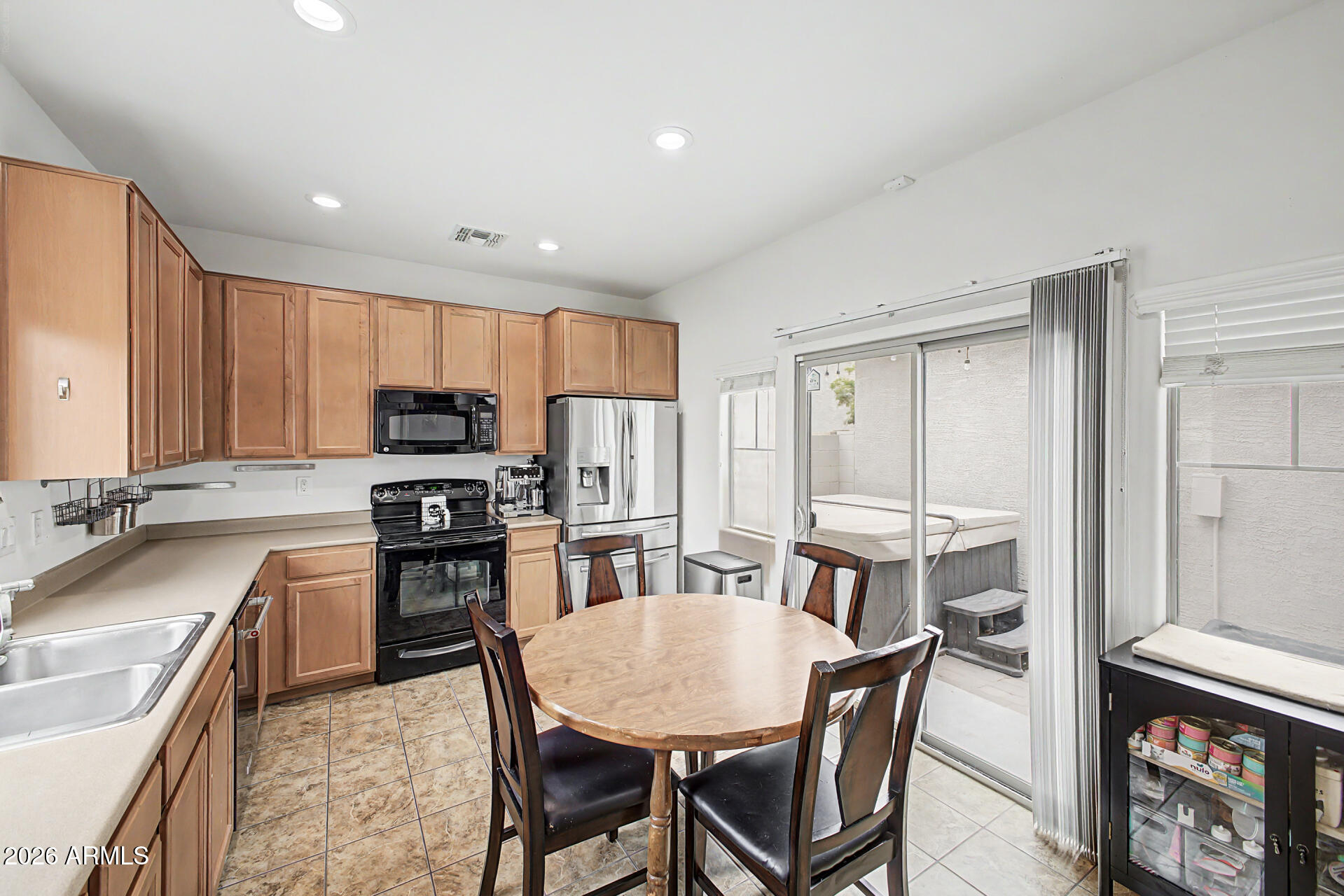 435 North Ranger Trail Gilbert, AZ 85234 - Photo 9 of 20 a kitchen with stainless steel appliances granite countertop a stove top oven a sink a dining table and chairs