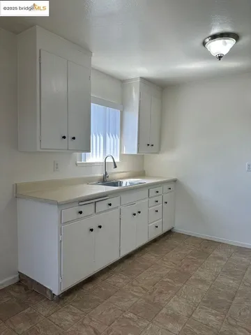 a kitchen with cabinets appliances a sink and a window
