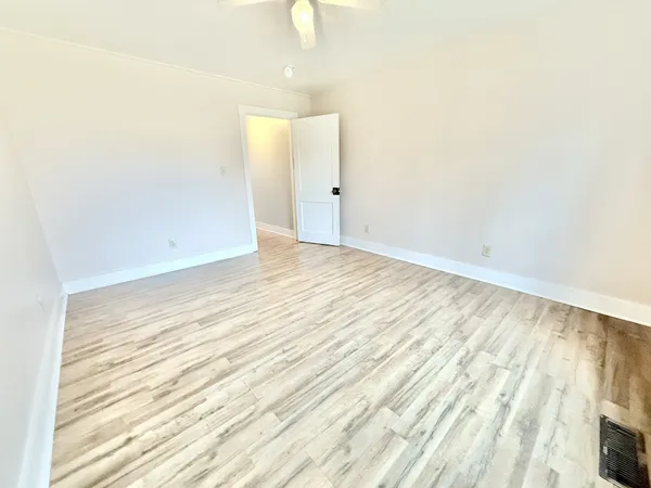 a view of an empty room with wooden floor