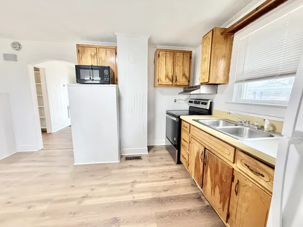 a kitchen with stainless steel appliances granite countertop a refrigerator a stove and a sink with wooden floor