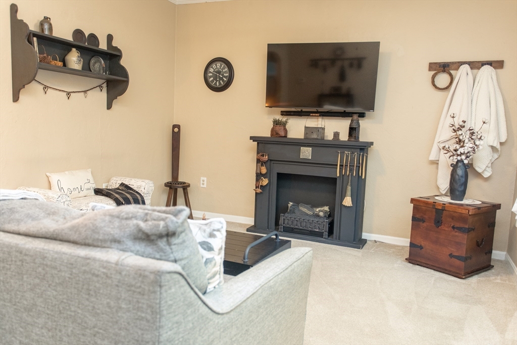 245 R Laurel Street East Bridgewater, MA 02333 - Photo 15 of 37 a living room with furniture a flat screen tv and a fireplace