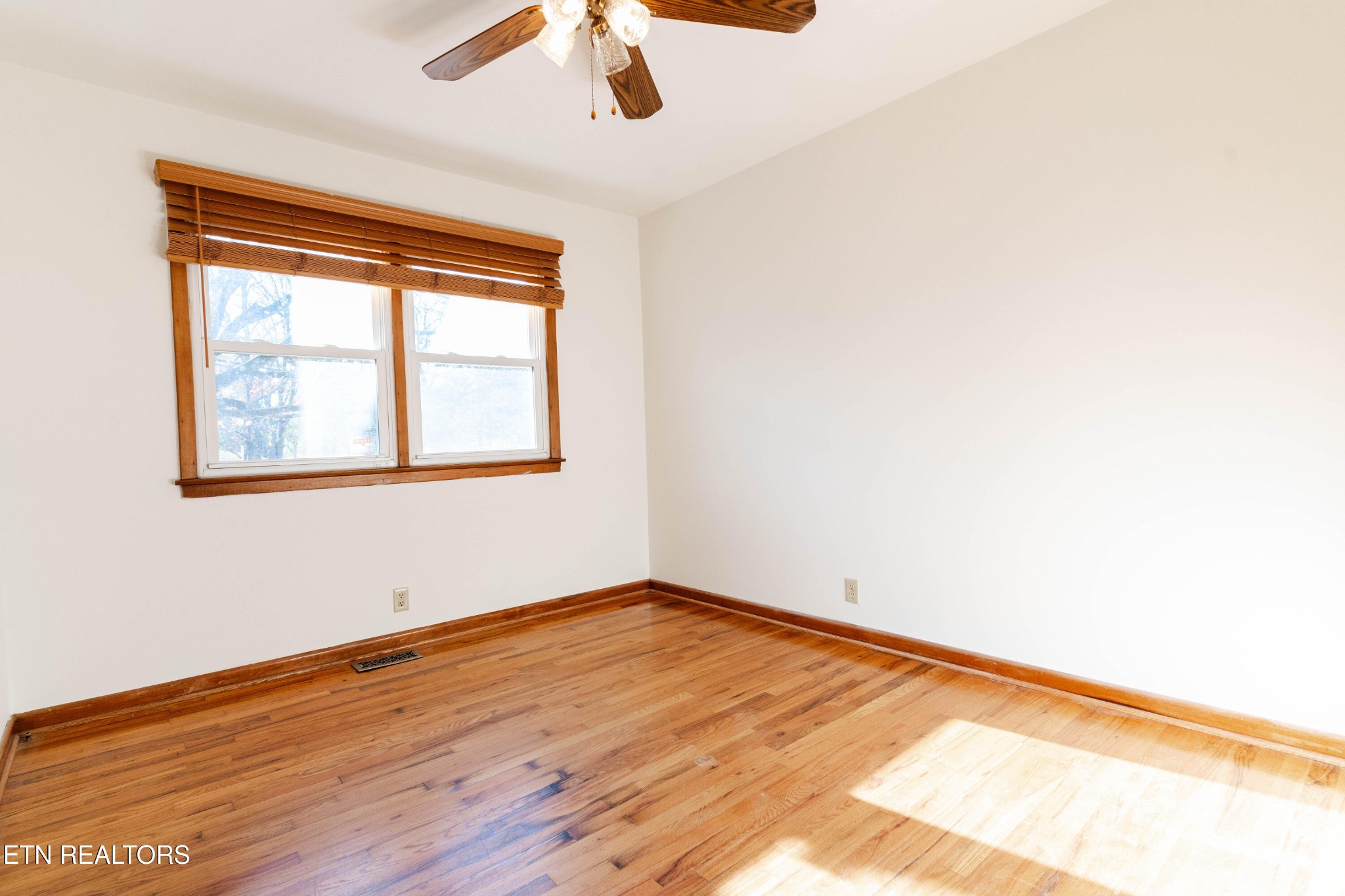 3424 Whittle Springs Road Knoxville, TN 37917 - Photo 10 of 29 an empty room with wooden floor fan and windows