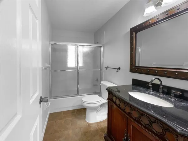 a bathroom with a granite countertop sink toilet and shower