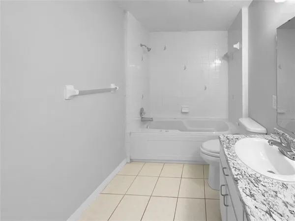 a bathroom with a granite countertop sink a toilet and a mirror