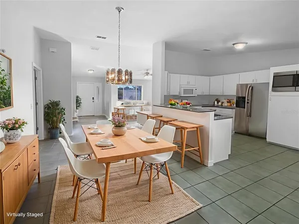 a kitchen with a dining table chairs and refrigerator
