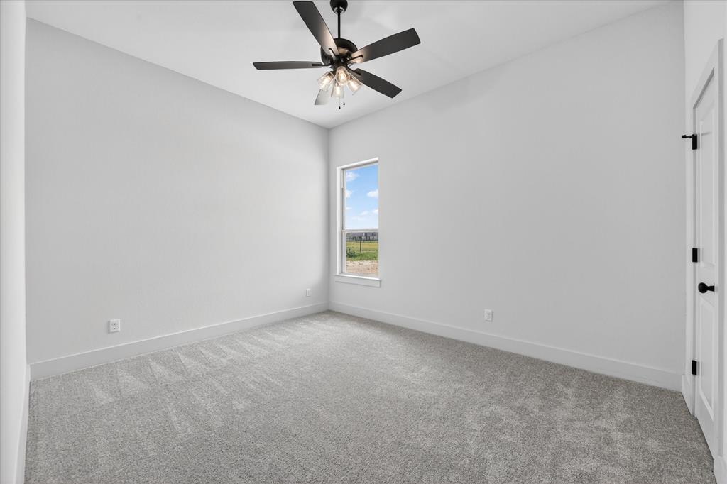 517 Longhorn Lane Springtown, TX 76082 - Photo 24 of 39 Empty room with light carpet and ceiling fan