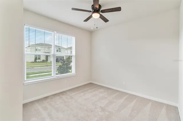 an empty room with a window and a fan